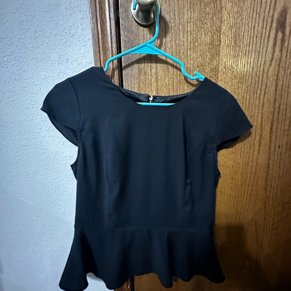 Peplum dressy shirt with zipper detail in back.